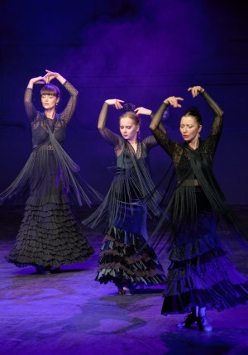 Na zdjęciu trzy tancerki flamenco w czarnych sukniach.