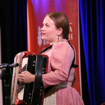 Na zdjęciu artystka grająca na akordeonie.