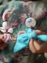 Zdjęcie dziecka trzymającego dwie motanki, niebieską i różową.