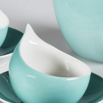 Zdjęcie lazurowej filiżanki w kształcie pół-łezki na spodku.