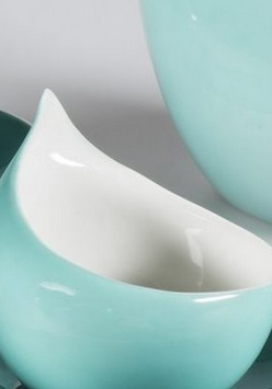 Zdjęcie lazurowej filiżanki w kształcie pół-łezki na spodku.