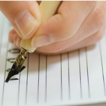 Zdjęcie dłoni z wiecznym piórem w trakcie kalilgrafowania.