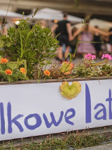 Zdjęcie tarasu budynku arkadii na którym tańczą ludzie. Miła atmosfera.