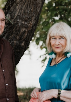 Zdjęcie mężczyzny i kobiety - uczestników spotkania - na tle drzew.