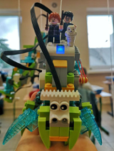 Robot z klocków Lego, przedstawiający bajkowe stworzenie na którym siedzą postaci znane z serii powieści Harry Potter.