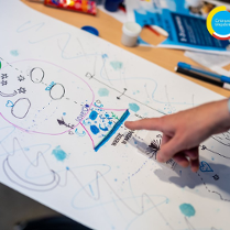 Zdjęcie pracy dziecka z dłonią wskazującą na jeden z elementów na rysunku.