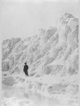 Zdjęcie z książki "Wszystkie światy ukryte" Agnieszki Zdziabek. Czarno-biała fotografia przedstawia mężczyznę stojącego na tle wielkiej śnieżnej zaspy.