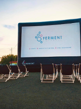 Duży ekran do wyświetlania filmów, a przed nim leżaki