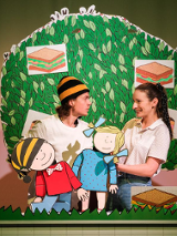 Zdjęcie przedstawiające dwóch aktorów na scenie z lalkami Gapiszona i Zuzi. W tle makieta drzewa.