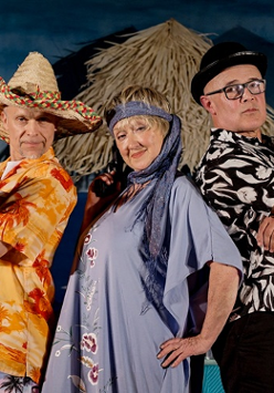 Dwóch mężczyzn i jedna kobieta, stoją obok siebie i patrzą w obiektyw. Ubrani sa w kolorowe stroje, jeden z mężczyzn trzyma mały pistolet.