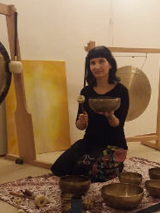 Baner wydarzenia: Kobieta gran na misach i gongach. Trzyma w ręku lisę i pałkę do grania, po lewej i w tyle wisi gong.