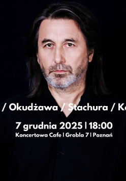 Zdjęcie ubranego na czarno mężczyzny, na ciemnym tle.