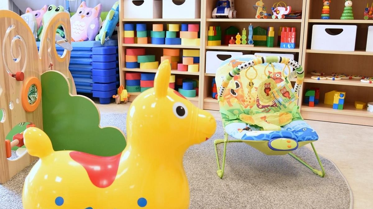 sala w żłobku, duzo kolorowych zabawek, klocków, ludzików, leżaczek i konik do skakania - grafika artykułu