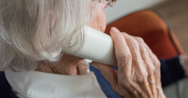Na zdjęciu starsza kobieta rozmawiająca przez telefon