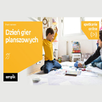 Na zdjęciu chłopiec i prawdopodobnie jego tata siedzą na podłodze i grają w planszówki. Po lewej w pomarańczowej ramce biały napis "Dzień gier planszowych".