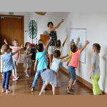 Grupa dzieci i animatorka w bawialni