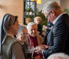 zdjecie przedstawia seniora i dwie zakonnice w rozmowie z prezydentem Miasta Poznania