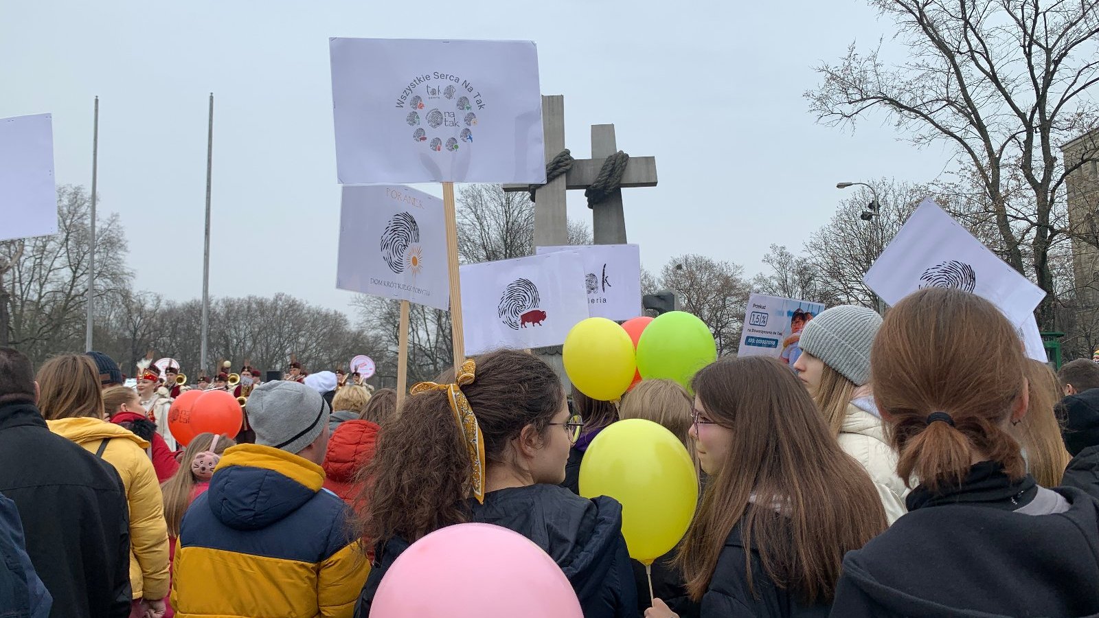 Grupa ludzi z balonami, transpartentem idzie ulicami Poznania