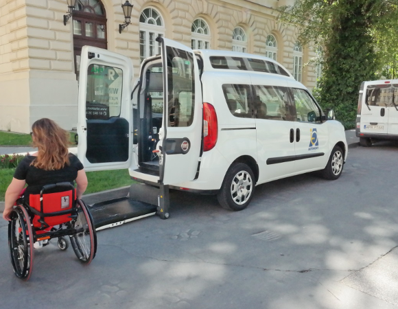 Osoba na wózku podjeżdża do otwartego samochodu