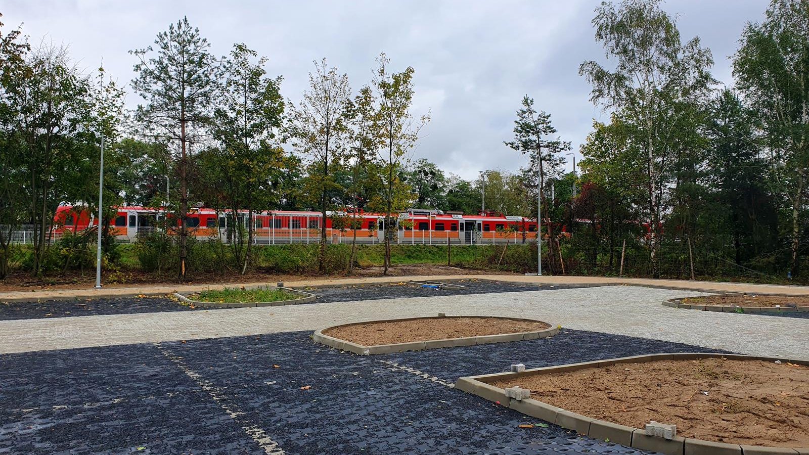 Budowany parking na Strzeszynie. W tle pociąg na stacji - grafika artykułu