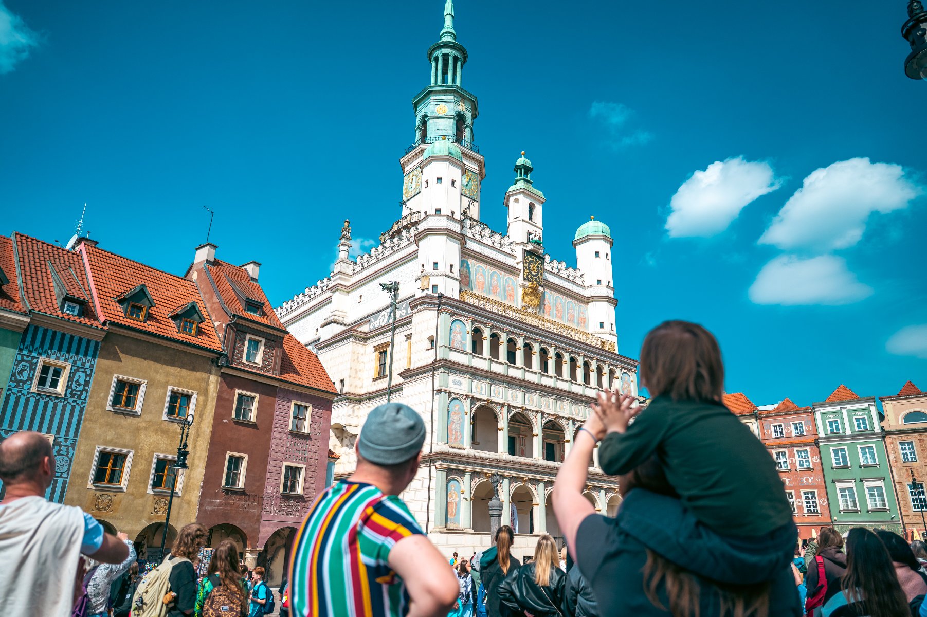 Ludzie na Starym Rynku obserwujący Ratusz i koziołki