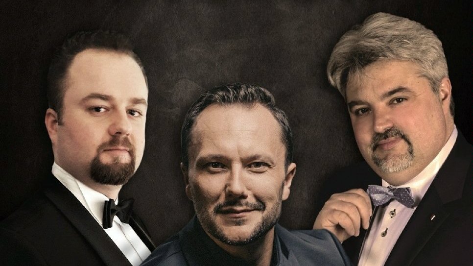 Zdjęcie przedstawia trzech muzyków w garniturach.