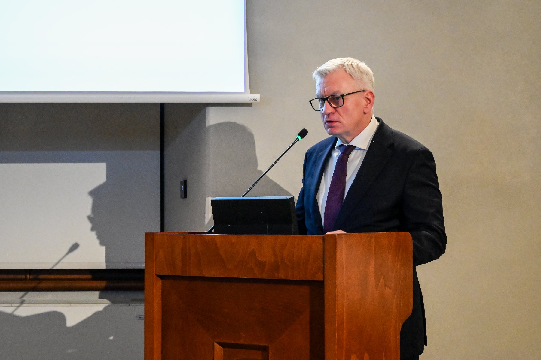 Na zdjęciu prezydent Poznania mówi coś przy mównicy w sali sesyjnej