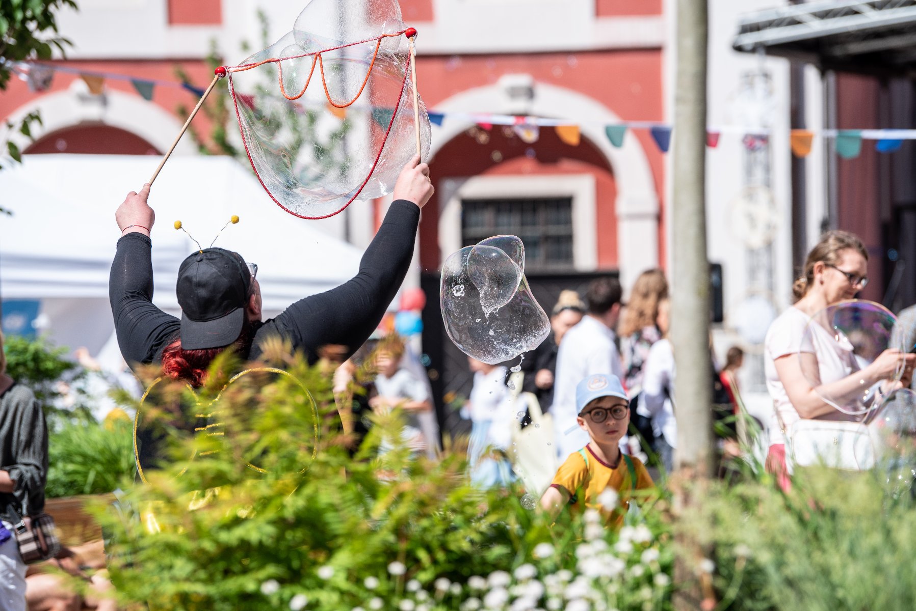 Poznańskie Dni Rodziny rozpoczną się piknikiem w parku, a zakończą - Dniem Dziecka Na zdjęciu Stary Rynek w Poznaniu, na pierwszym planie dziecko siedzące na plecach dorosłego