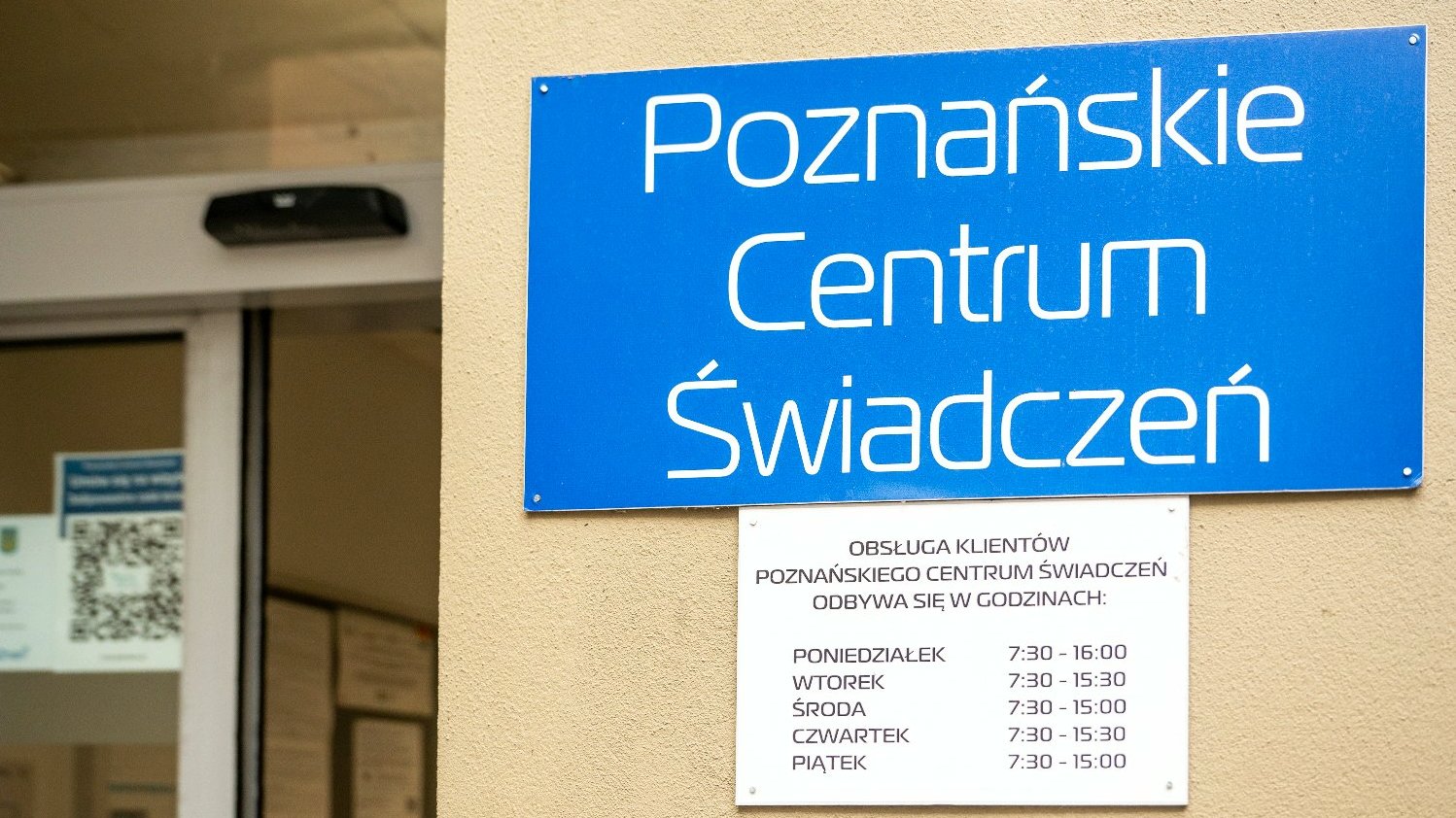 Na zdjęciu wejście do Poznańskiego Centrum Świadczeń, widać tabliczkę z nazwą PCŚ