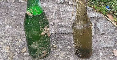 Zdjęcie przedstawia dwie butelki wyłowione z wody.