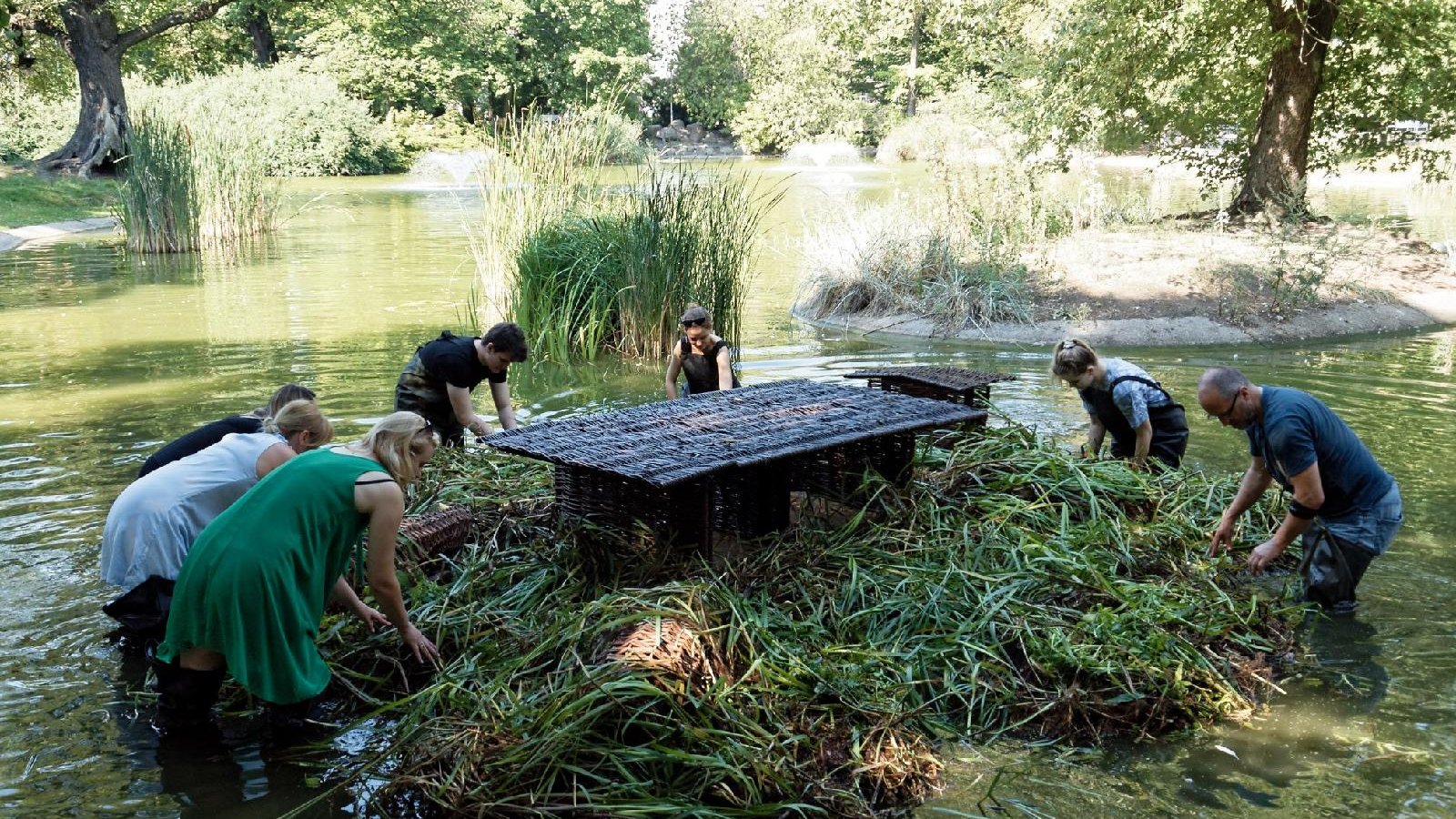 Na zdjęciu znajdują się przedstawiciele Fundacji OnWater.pl, którzy montują ogród pływający na stawie w parku Wilsona