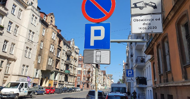 Zdjęcie przedstawia ul. Wierzbięcice. Widać na nim samochody oraz znaki informujące o zakazie parkowania