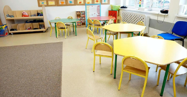 Sala lekcyjna/świetlica. Pod ścianami kolorowe stoły dla dzieci, wokół nich krzesła, w tle liczydło
