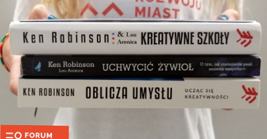 Kobieta trzymająca przed sobą trzy książki autorstwa Kena Robinsona - nie widać jej twarzy. Na bluzce ma napis: Forum Rozwoju Miast
