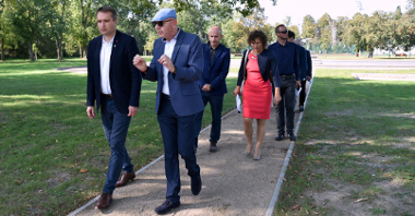 Zdjęcie przedstawia spacerujących przedstawicieli Miasta Poznania, domu kultury i wykonawcy prac.