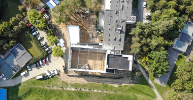 Zdjęcie przedstawia budynek szkoły w trakcie rozbudowy, widziany z góry.