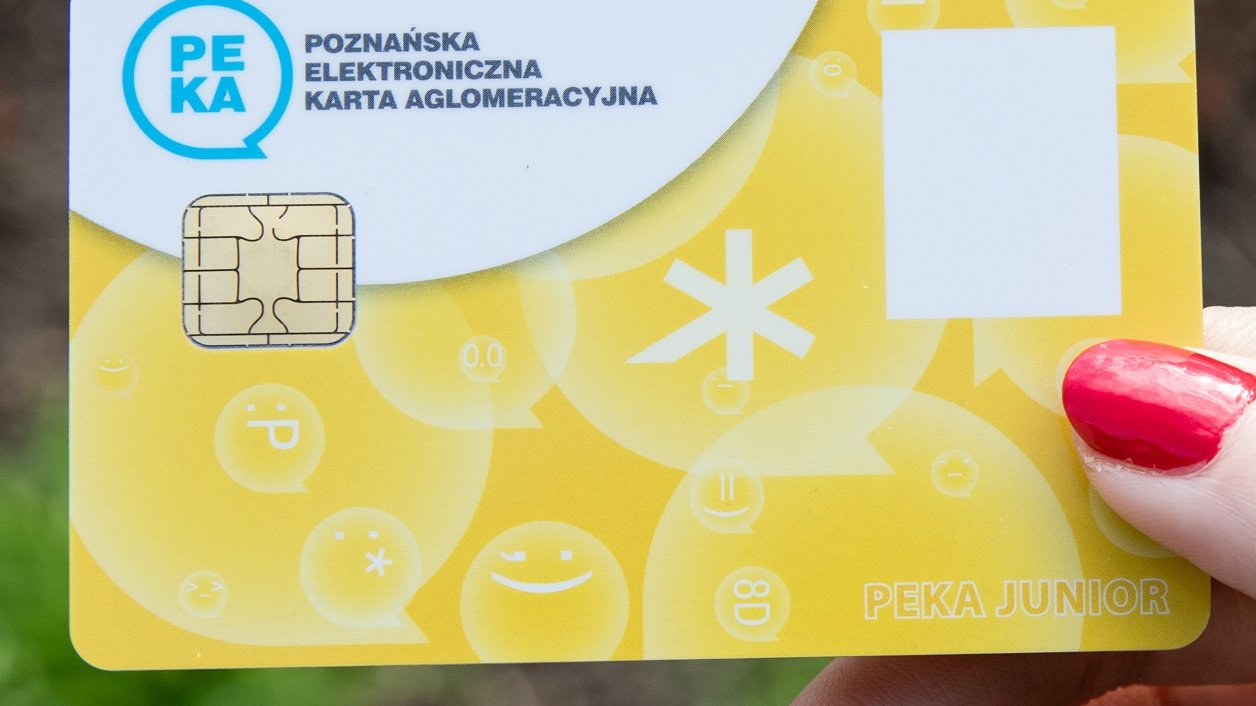 Żółta PEKA Junior. W tle tramwaj