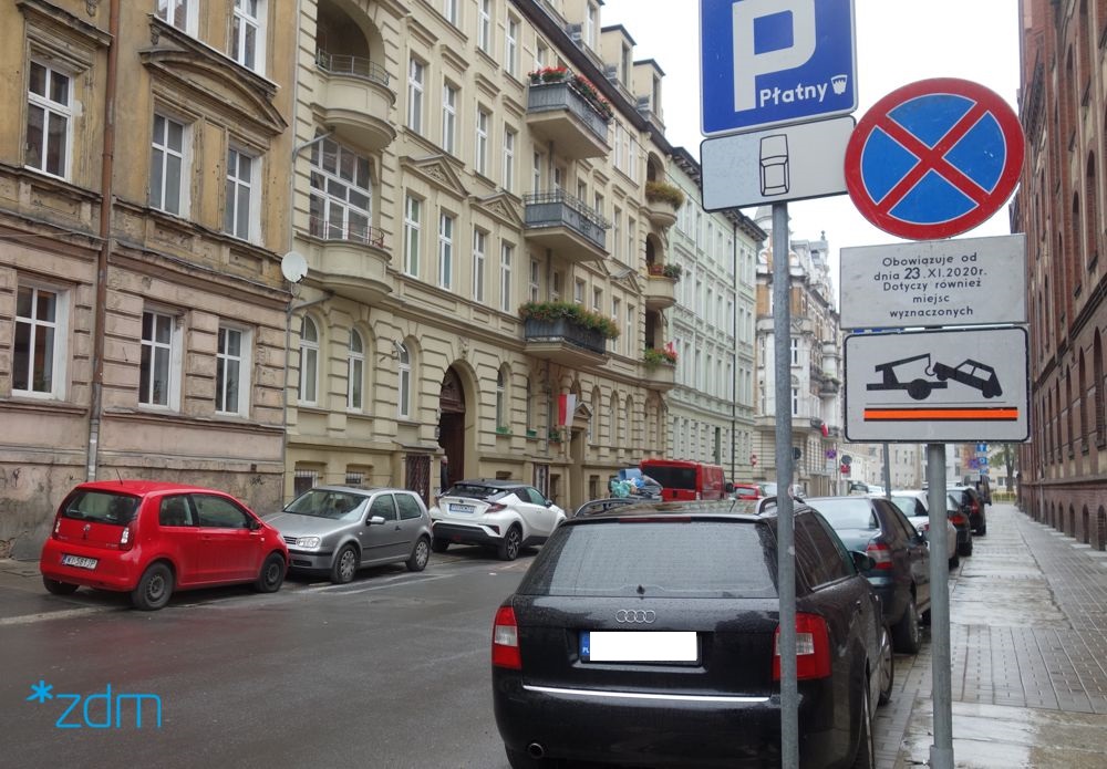 Ulica Kwiatowa z zaparkowanymi samochodami i znakiem drogowym - grafika artykułu