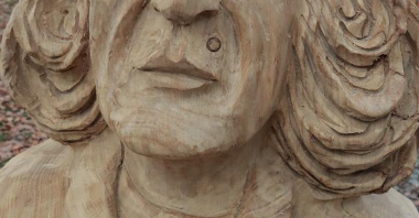 Zdjęcie przedstawia drewnianą rzeźbę Mikołaja Kopernika.