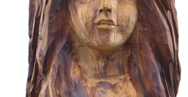 Zdjęcie przedstawia drewnianą rzeźbę dziewczyny.