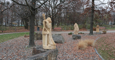 Zdjęcie przedstawia drewniane rzeźby w parku.