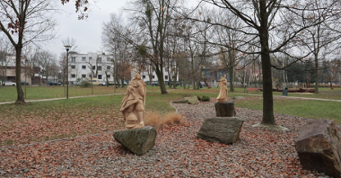 Zdjęcie przedstawia drewniane rzeźby w parku.