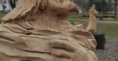 Zdjęcie przedstawia drewnianą rzeźbę w parku.