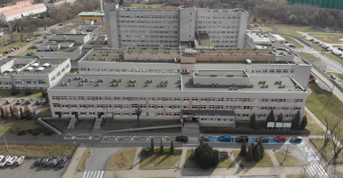 Zdjęcie przedstawia szpital im. J. Strusia widziany z lotu ptaka, na pierwszym planie główne wejście i parking