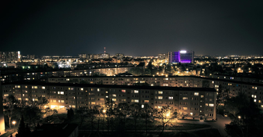 Zdjęcie przedstawia osiedle Przyjaźni wykonane nocą, z góry. Na fotografii widać rozświetlone bloki.