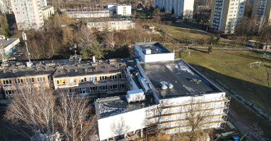 Galeria zdjęć przedstawia salę gimnastyczną, która powstaje przy szkole na osiedlu Sobieskiego. Zdjęcia zrobiono z góry. Wokół widać bloki.