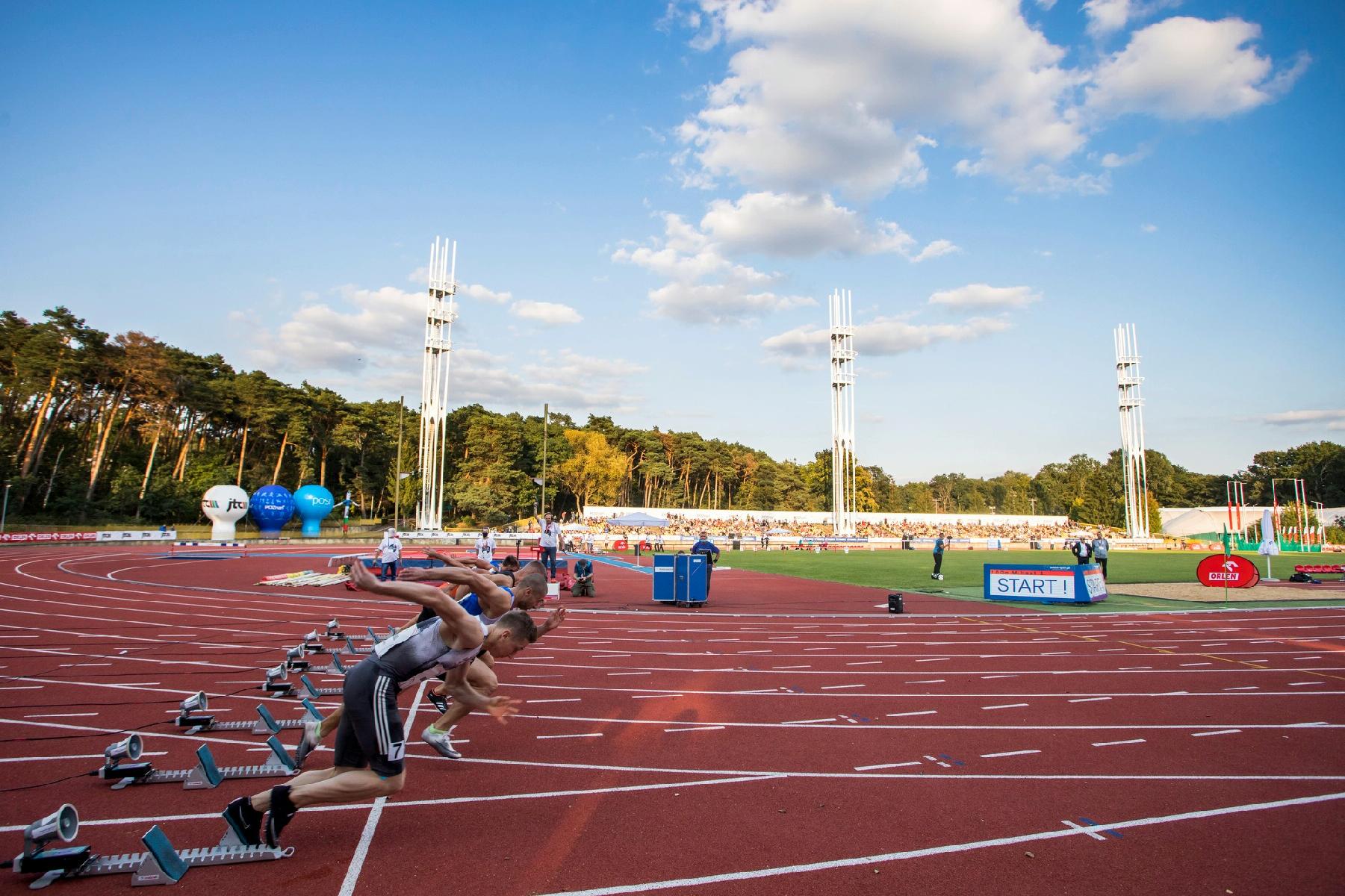 Zdjęcie przedstawia biegnących po torze mężczyzn. Fotografia została zrobiona na stadionie na Golęcinie. - grafika artykułu