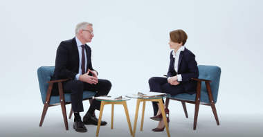 Kard z filmu: na krzesłach, przy stoliku siedzą Jacek Jaskowiak i Jadwiga Emilewicz, rozmawiają