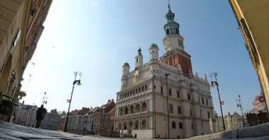 Zdjęcie przedstawia poznański Ratusz na Starym Rynku, widziany spod arkady