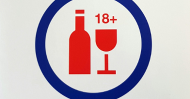 Grafika: butelka i kieliszek, obok liczba 18+, w niebieskim okręgu